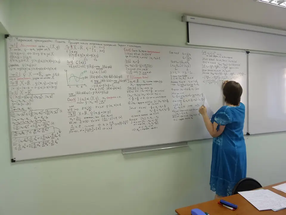 A mathematician writes formulas on a whiteboard