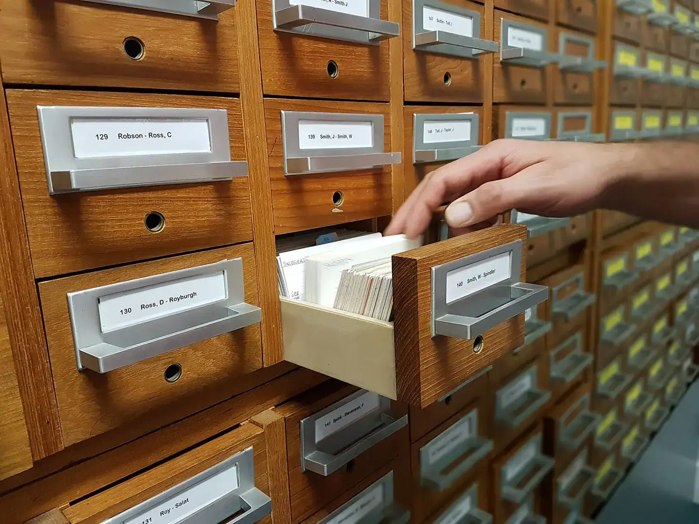 A hand selecting a card in a filing cabinet at a CTC hack weekend